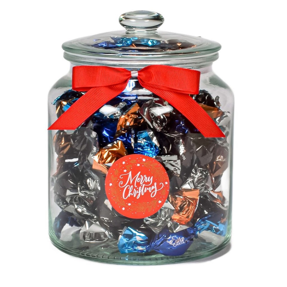 Assorted Chocolate Truffles In A Glass Jar And A Merry Christmas Festive Sticker Tied With a Small Red Bow