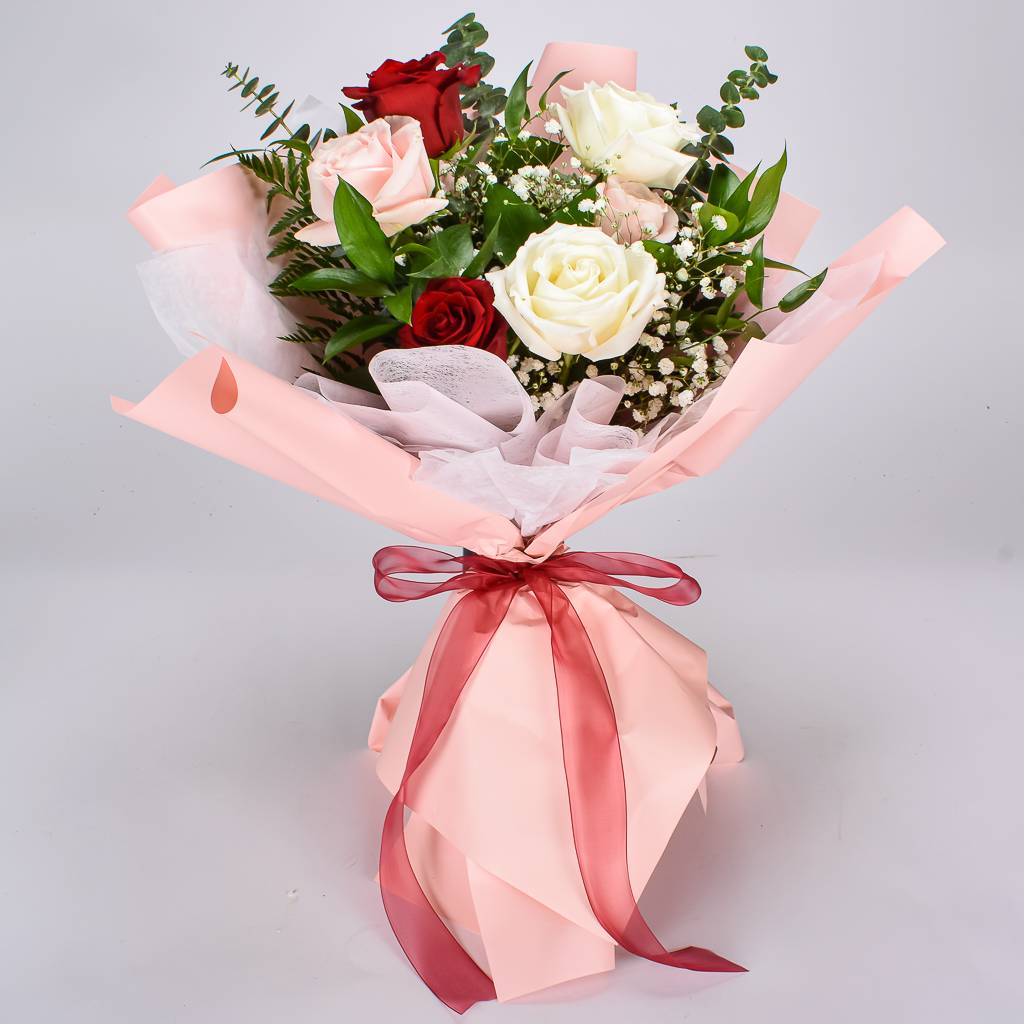 Beautifully Wrapped Bouquet Wth 6 Mixed Coloured Roses With Lush Greenery Wrapped in Pink Korean Paper