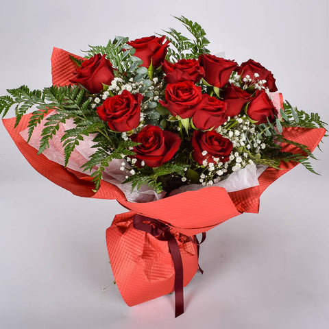 12 Red Roses, Lush Greenery and Baby's Breath Wrapped In Red Floral Paper 